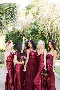 the bride and her bridesmaids are posing for pictures in their red gowns