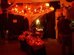 a man standing in front of a table filled with food and lights on it's ceiling