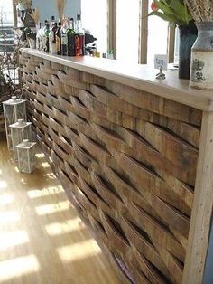 a wooden bar with lots of bottles on it's back wall in a room