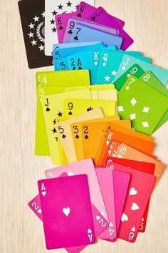 colorful playing cards with numbers and symbols on the front, sitting on a wooden surface