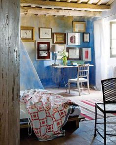 a bedroom with blue walls and pictures on the wall