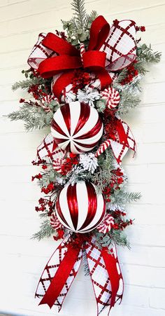 a red and white christmas wreath hanging on the side of a building with candy canes