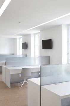 an empty office with desks and chairs in the middle of it, all white