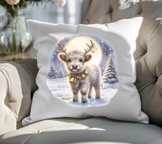 a white pillow with an image of a deer wearing a gold bell on it's head