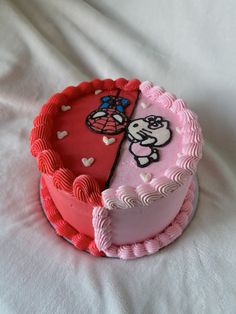 two cakes decorated with pink and red frosting on top of a white table cloth