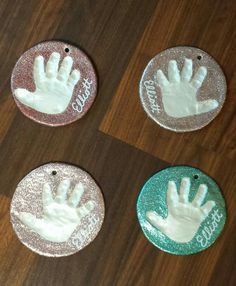 four handprinted ornament ornaments on a table