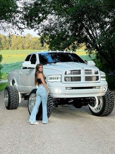 a woman standing next to a silver truck