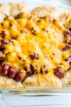 a casserole dish with hot dogs and cheese on top, ready to be eaten