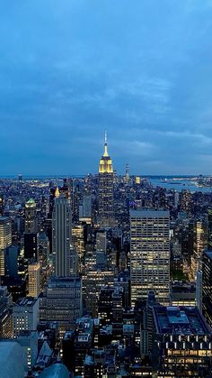 the city skyline is lit up at night, with skyscrapers in the foreground