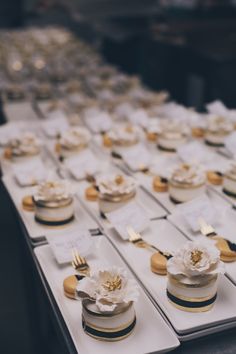 a table topped with lots of white and gold desserts