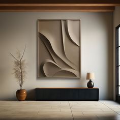 an abstract painting hangs on the wall next to a vase with a plant in it