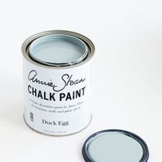 a can of chalk paint sitting on top of a white table next to a black lid