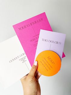 a person holding three different colored business cards in their left hand and the other one with an orange circle on it