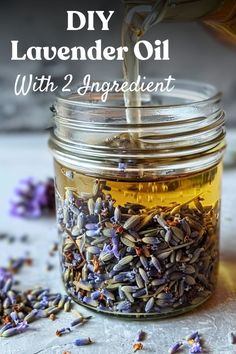 lavender oil being poured into a glass jar with lavenders scattered around it and the words diy lavender oil with 2 ingredient