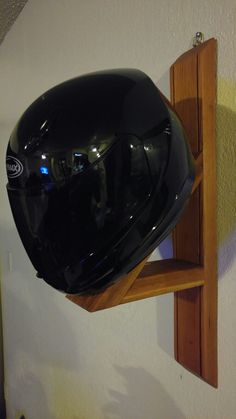 a motorcycle helmet mounted to the side of a wooden shelf with a mirror on it