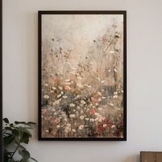 a painting hanging on the wall next to a potted plant