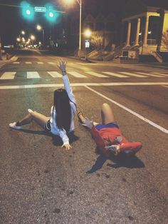 two people laying on the ground in the street