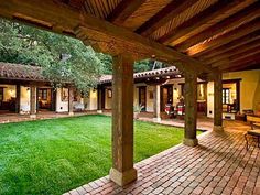 an outdoor patio with brick pavers and green grass