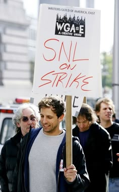 a man holding a sign with writing on it