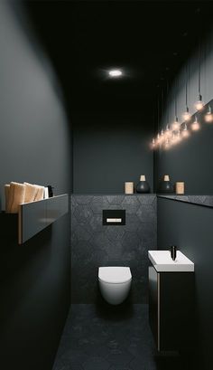 a black and white bathroom with lights above the toilet