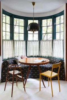 two chairs and a table in front of a bay window