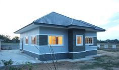 a small blue house sitting on top of a dirt field