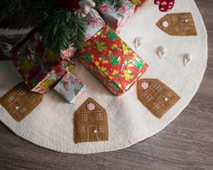 presents are wrapped in colorful paper and placed on a round rug with gingerbread houses