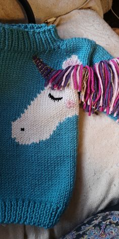 a knitted blanket with a unicorn face on it