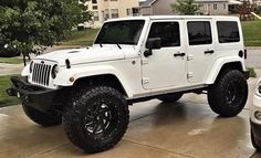 a white jeep parked in front of a house