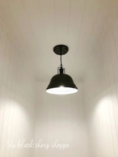 an empty room with three lights hanging from the ceiling