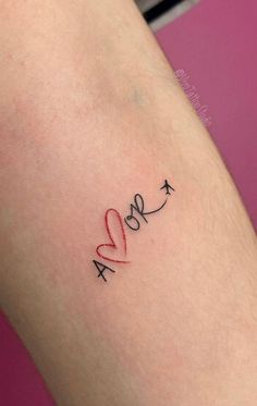 a woman's arm with an arrow and heart tattoo on the left side of her leg