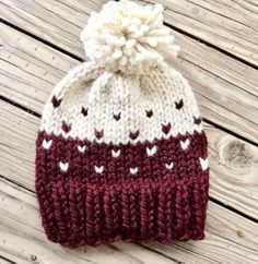 a red and white knitted hat with hearts on it