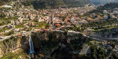 an aerial view of a city and waterfall