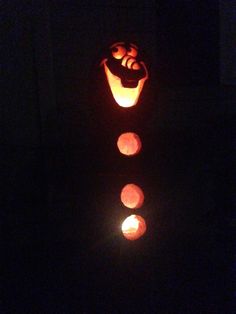 a pumpkin carved to look like it has four faces on it and is lit up in the dark