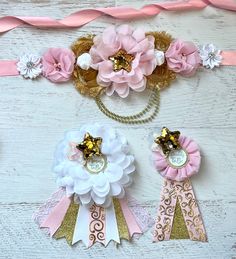 pink and white flowers are on top of ribbons with gold trim around the edges, along with other decorative items