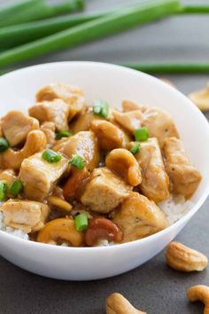 a white bowl filled with chicken and cashews