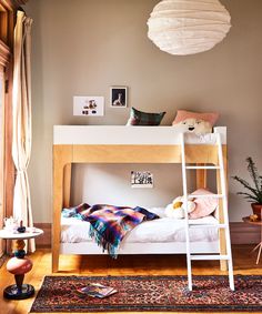 a bedroom with a bunk bed, rugs and pictures on the wall above it