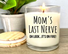 a candle that says mom's last nerve on it next to a cookie