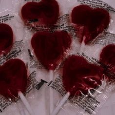 four heart shaped lollipops wrapped in plastic wrappers