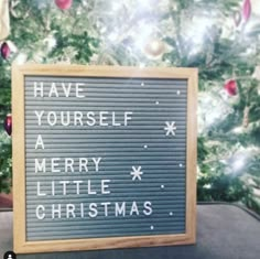 a sign that says have yourself a merry little christmas written on it in front of a christmas tree