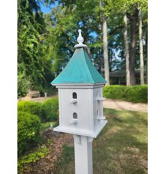 a white bird house with a blue roof