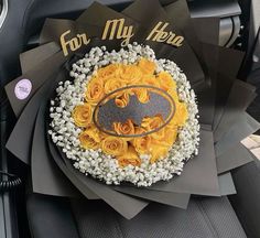 a cake decorated to look like a batman symbol with flowers and frosting on it