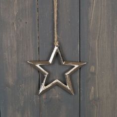 a metal star hanging on a wooden door with rope around it's edge and two smaller stars in the middle