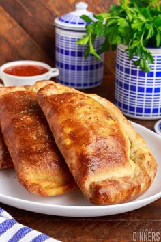 two pieces of bread on a plate with sauces and parsley in the background