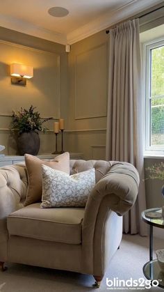 a living room filled with furniture next to a window covered in curtains and drapes