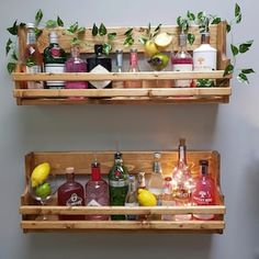 two wooden shelves filled with liquor bottles and glasses on top of each other, one shelf holding drinks