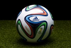 a soccer ball sitting on top of a green field