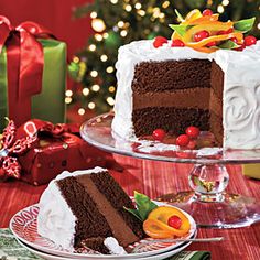 two slices of chocolate cake on plates next to a christmas tree