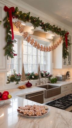 a kitchen decorated for christmas with gingerbread cookies on the counter and garland hanging from the ceiling