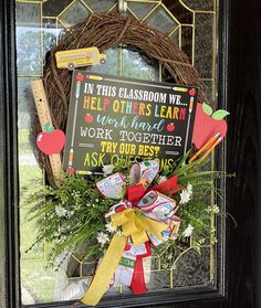 a wreath on the front door with an apple teacher's day sign and pencils